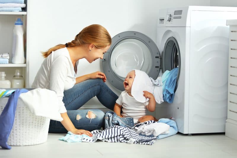 Mother and baby doing laundry and goofing around